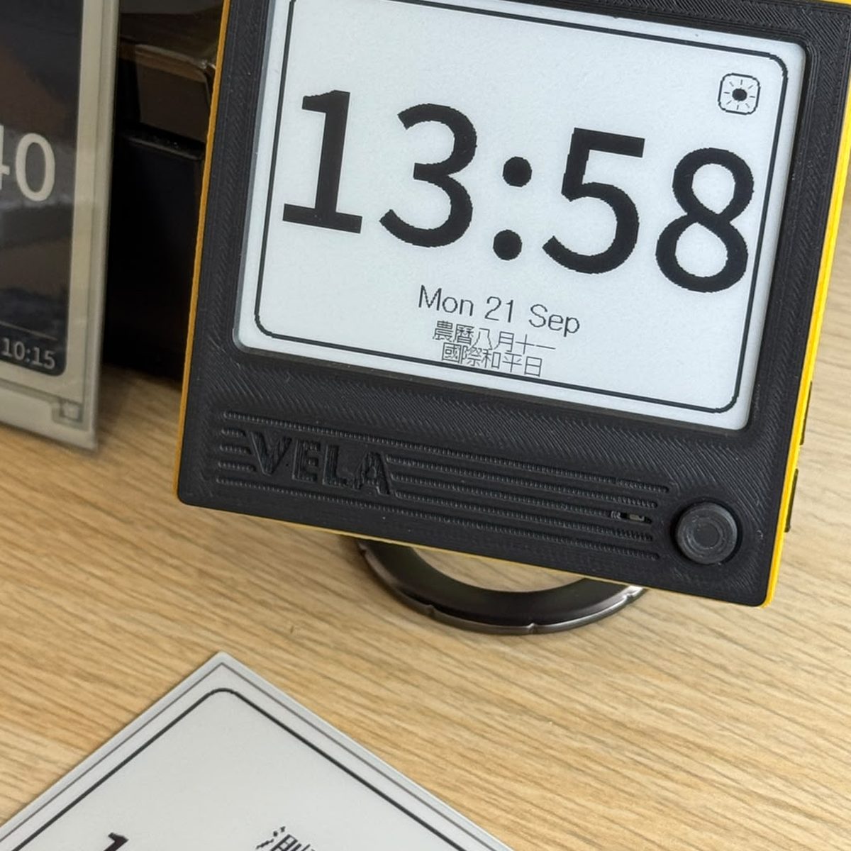 A VELA 42BW on a desk, showing 時鐘